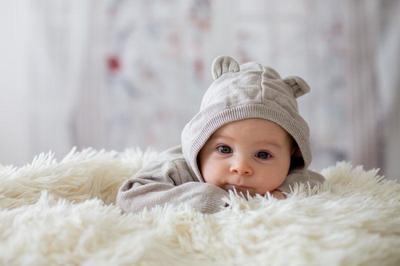 戴帽子的可愛嬰兒圖片-趴在毛絨絨毯子上的可愛嬰兒素材-高清圖片-攝影 .